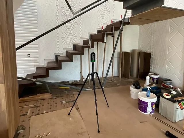 Scaner laser 3D pe trepied, lângă o scară interioară