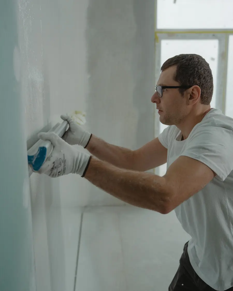 Worker smoothing fresh plaster on a wall
